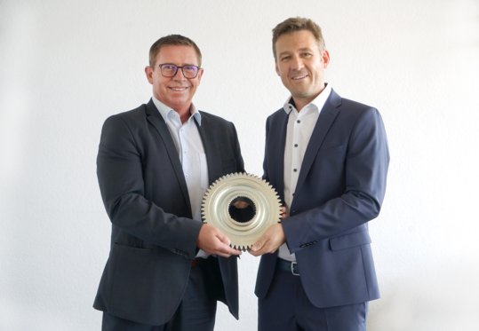 Philippe Maetz und Philipp Krenn gemeinsam am Bild, halten ein Zahnrad